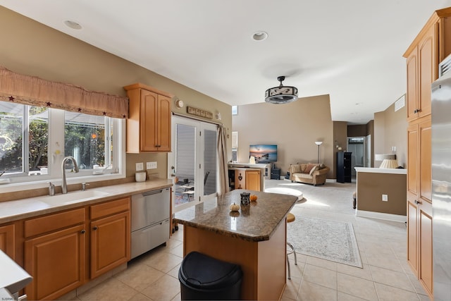 kitchen with a kitchen island, a kitchen breakfast bar, sink, light tile patterned flooring, and stainless steel dishwasher