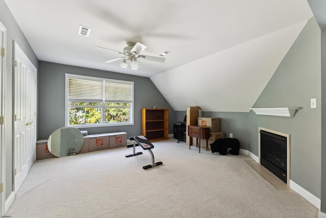 workout room with light carpet, lofted ceiling, and ceiling fan