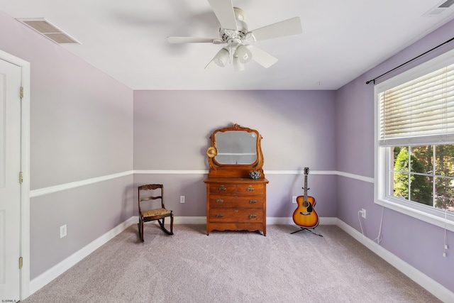 living area with light carpet, a healthy amount of sunlight, and ceiling fan