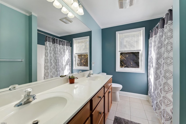 bathroom featuring vanity, toilet, a healthy amount of sunlight, and tile patterned flooring