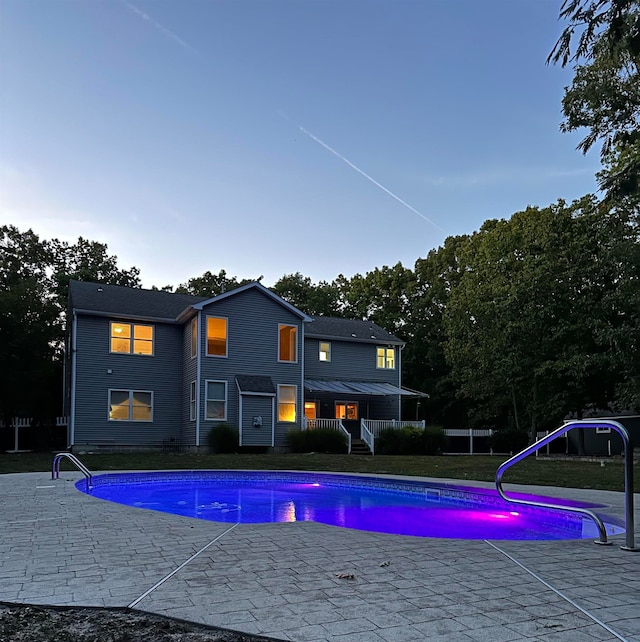 pool at dusk featuring a patio area