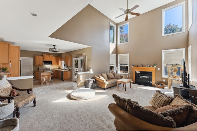 carpeted living room featuring ceiling fan and high vaulted ceiling