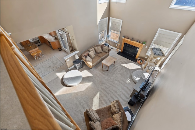 living room featuring a towering ceiling and light colored carpet