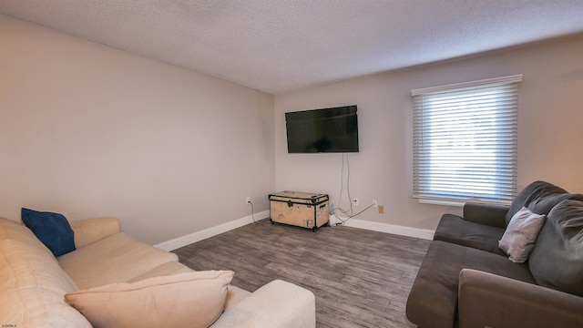 living room featuring a textured ceiling and dark hardwood / wood-style floors