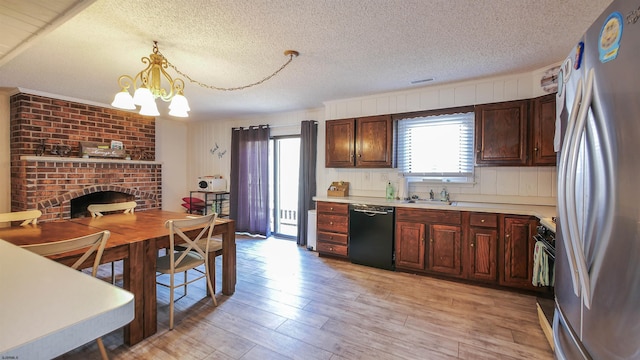 kitchen featuring an inviting chandelier, light wood-type flooring, stainless steel refrigerator, dishwasher, and decorative light fixtures