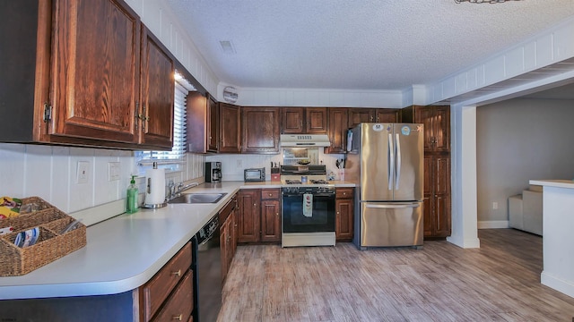 kitchen with white gas range, light wood-type flooring, stainless steel refrigerator, dishwasher, and sink