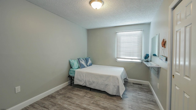 bedroom with hardwood / wood-style flooring and a textured ceiling