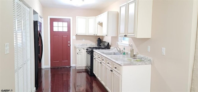 kitchen featuring a healthy amount of sunlight, black appliances, sink, white cabinetry, and dark hardwood / wood-style floors