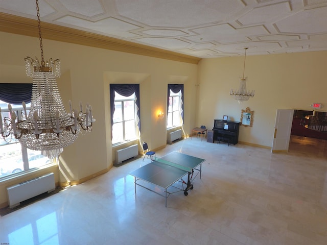 recreation room with radiator heating unit, a healthy amount of sunlight, and an inviting chandelier