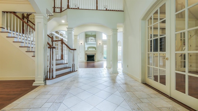 foyer entrance with light wood-type flooring and a towering ceiling