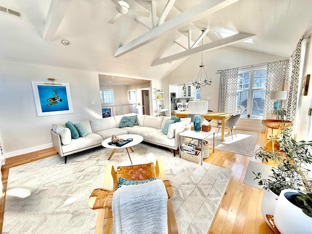 living room featuring light hardwood / wood-style flooring, beam ceiling, and a healthy amount of sunlight