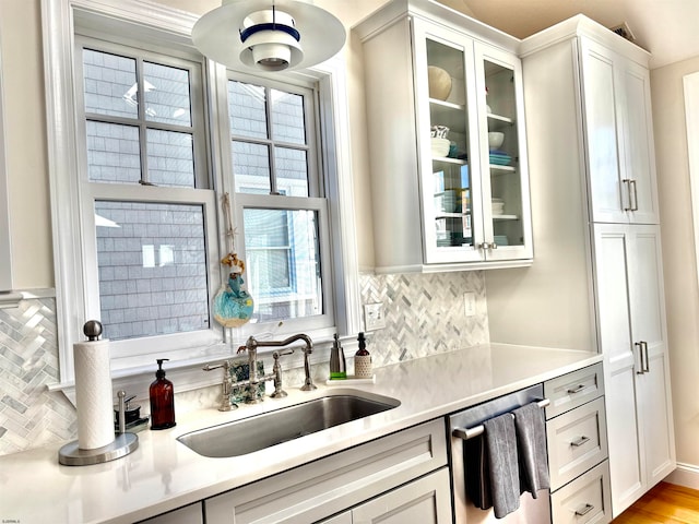 bar featuring white cabinetry, sink, backsplash, and a wealth of natural light