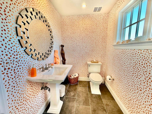 bathroom featuring toilet and tile patterned flooring