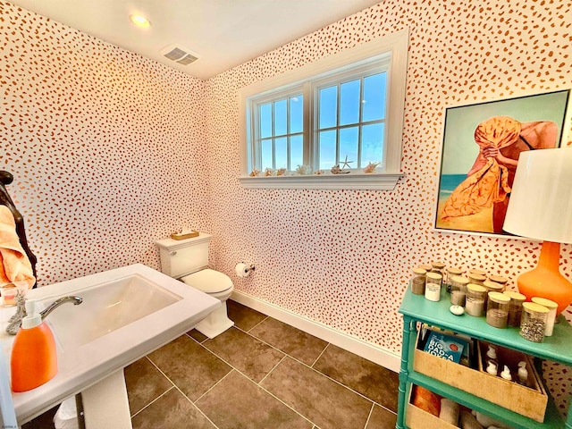 bathroom with toilet and tile patterned floors