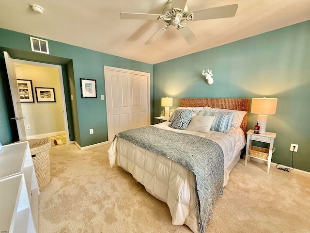 bedroom with a closet, light colored carpet, and ceiling fan