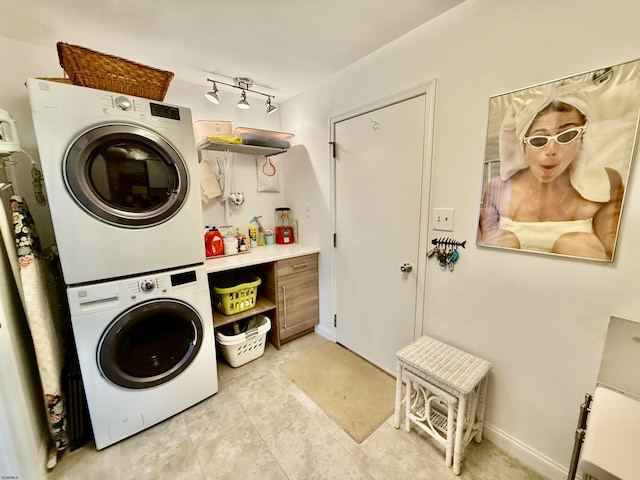 clothes washing area featuring stacked washer and clothes dryer