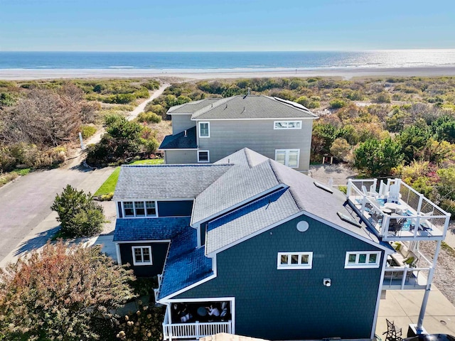 birds eye view of property with a water view and a beach view