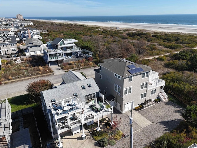 drone / aerial view featuring a water view and a view of the beach