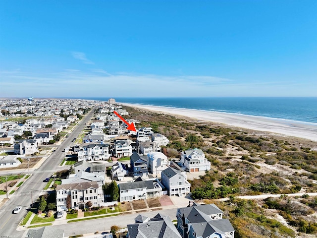 drone / aerial view with a water view and a beach view