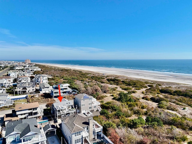 birds eye view of property with a water view and a beach view