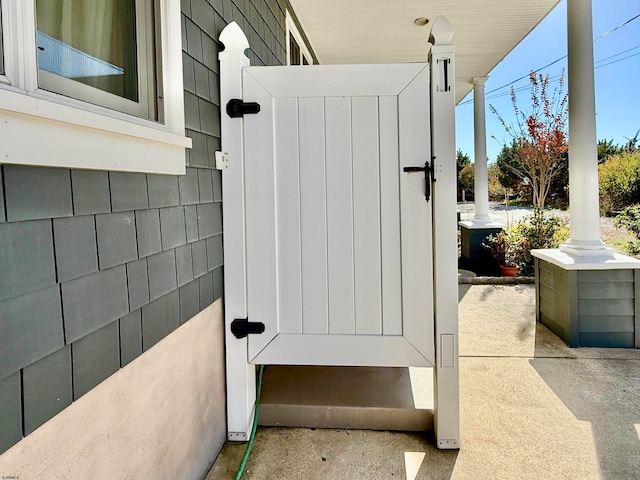 exterior space with concrete floors and decorative columns