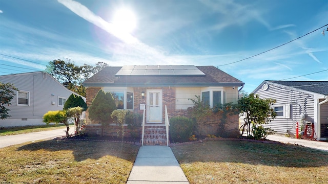 bungalow-style home with solar panels and a front yard