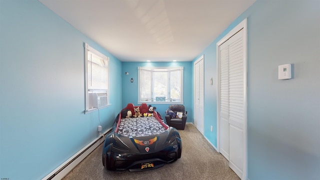 bedroom with baseboard heating and light carpet