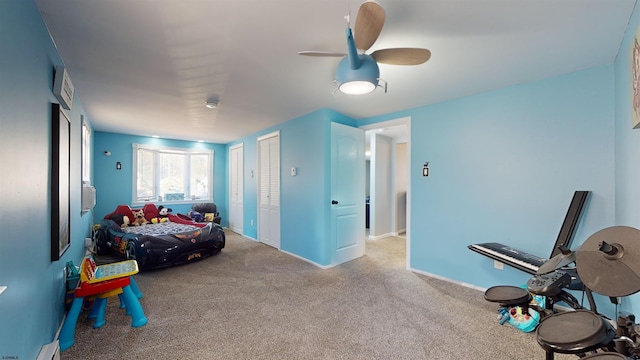 carpeted bedroom with baseboard heating and ceiling fan