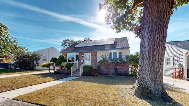 view of front facade with a front yard and solar panels