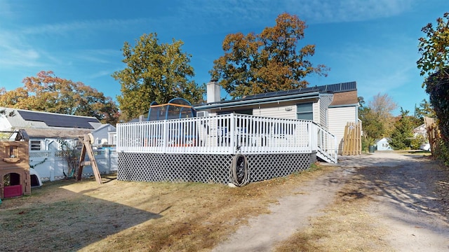 rear view of house featuring a wooden deck