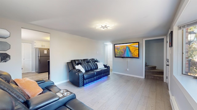 living room featuring a baseboard heating unit and light wood-type flooring