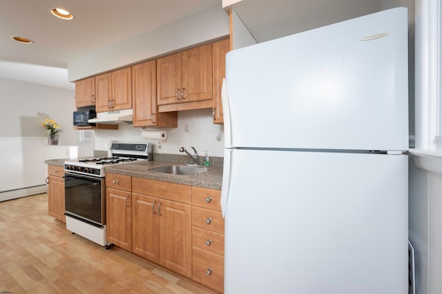 kitchen featuring baseboard heating, light hardwood / wood-style flooring, sink, white appliances, and tasteful backsplash