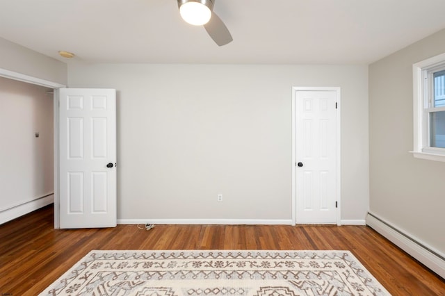 unfurnished bedroom with a baseboard radiator, hardwood / wood-style floors, and ceiling fan