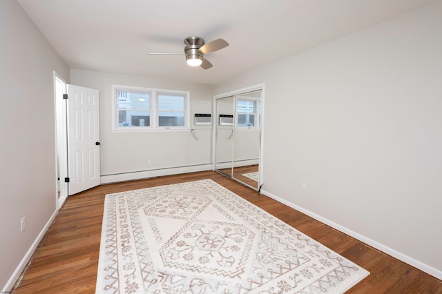 interior space with hardwood / wood-style floors, a baseboard radiator, and ceiling fan