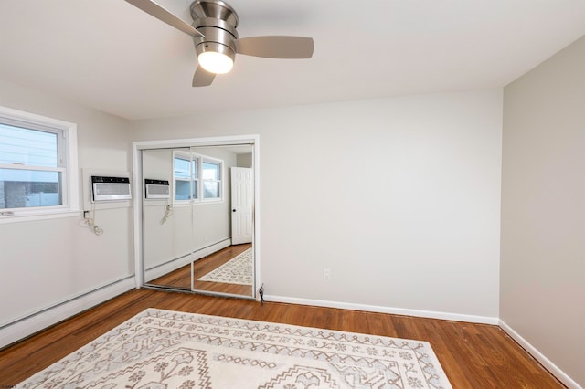 foyer with a baseboard radiator, wood-type flooring, plenty of natural light, and ceiling fan