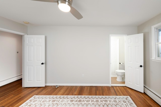 unfurnished bedroom with ensuite bath, wood-type flooring, a baseboard radiator, and ceiling fan