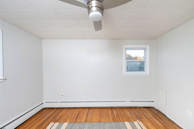 empty room with baseboard heating, light hardwood / wood-style floors, and ceiling fan