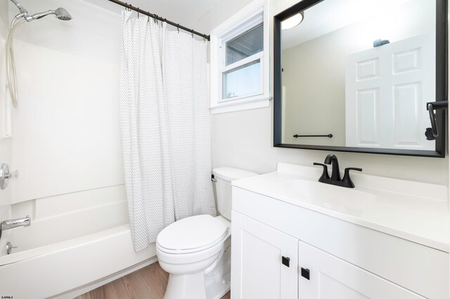 full bathroom with vanity, toilet, hardwood / wood-style flooring, and shower / bath combo