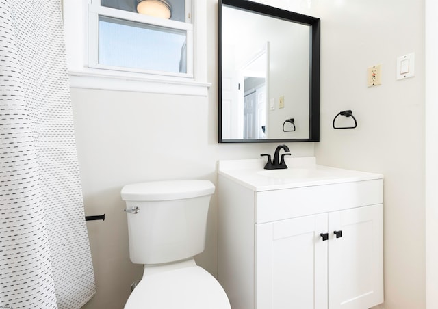 bathroom with vanity, curtained shower, and toilet