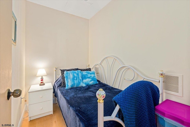 bedroom featuring vaulted ceiling and light wood-type flooring