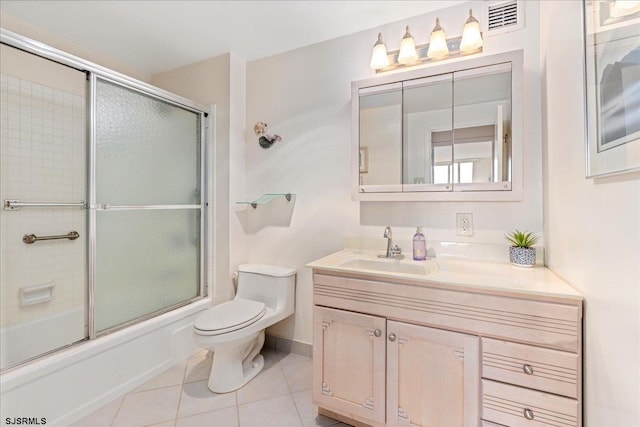 full bathroom featuring vanity, shower / bath combination with glass door, toilet, and tile patterned flooring