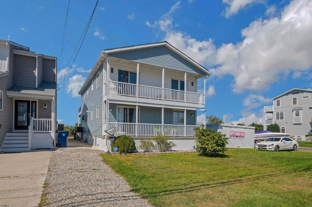 view of front of house featuring a front lawn and a balcony