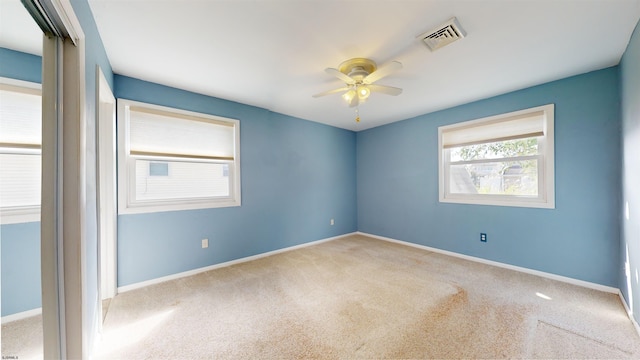 carpeted spare room featuring ceiling fan