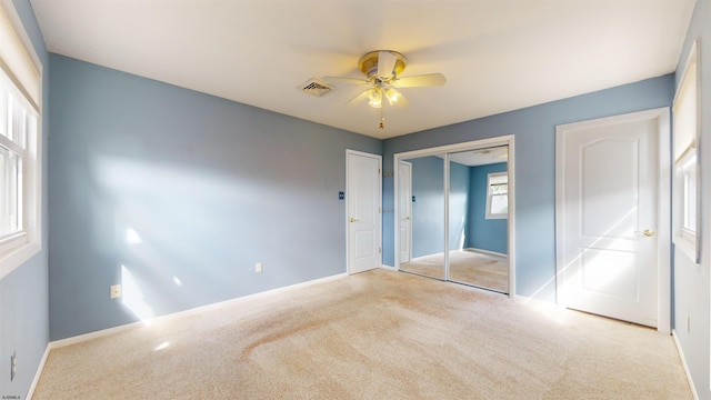 unfurnished bedroom featuring light colored carpet and ceiling fan