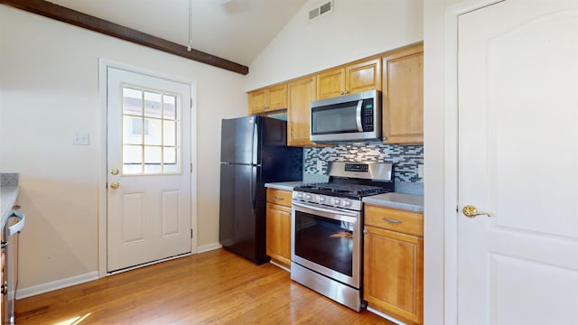 kitchen with light hardwood / wood-style floors, lofted ceiling, decorative backsplash, and stainless steel appliances