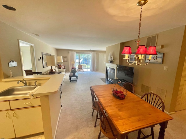 carpeted dining space with sink and a chandelier