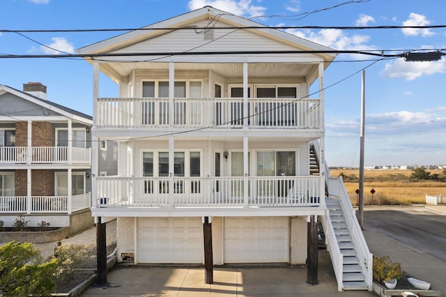 raised beach house featuring a balcony and a garage