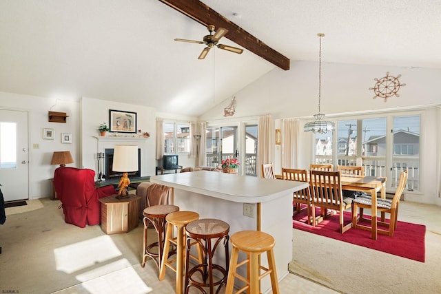 kitchen with ceiling fan, beamed ceiling, a wealth of natural light, and light colored carpet