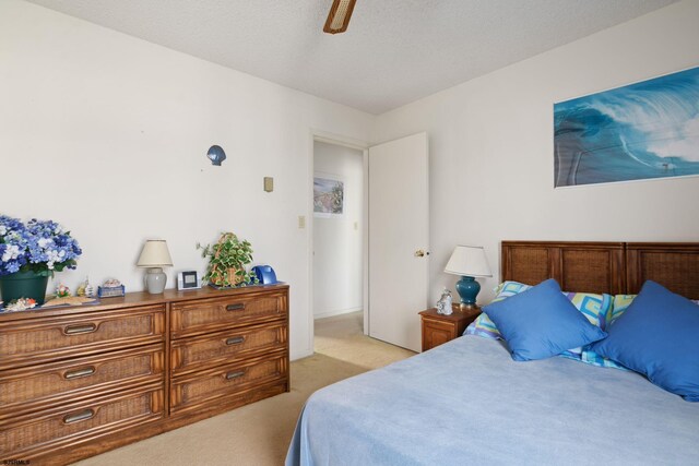 carpeted bedroom with a textured ceiling and ceiling fan