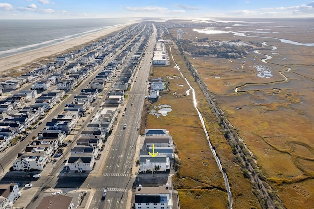 drone / aerial view featuring a water view and a beach view